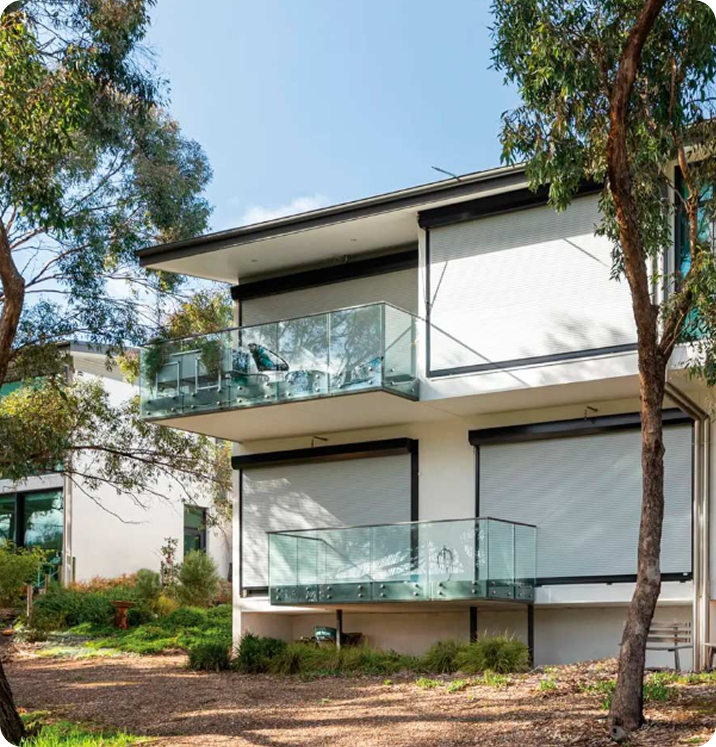 Modern home with roller shutters and glass balustrade balcony